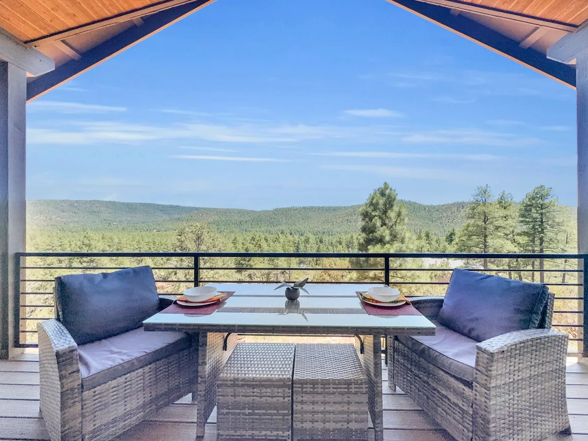 An inviting outdoor dining area with panoramic views of the lush forest, comfortable seating, and space for the whole family to enjoy meals together while immersed in nature’s tranquility.